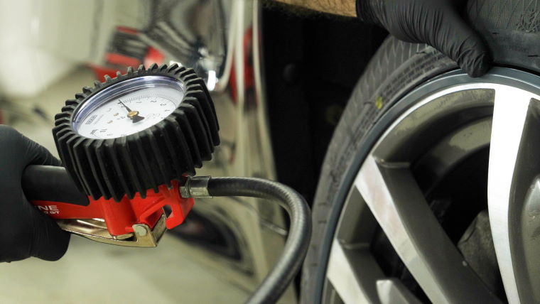 Technician checking tyre pressure