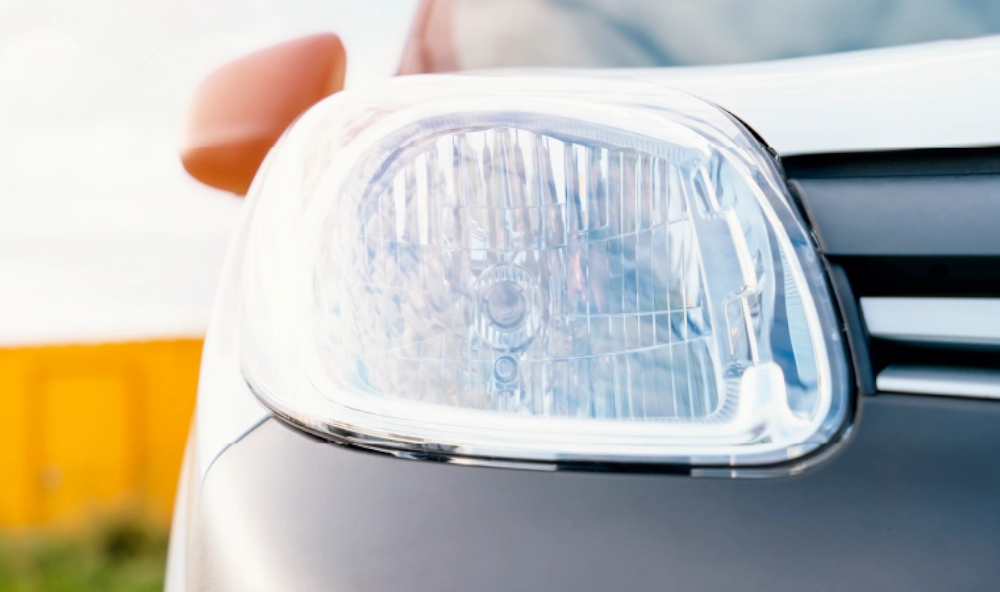 A headlight on a white and grey car.